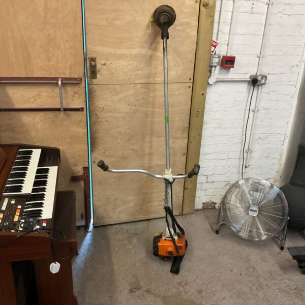 Used Stihl strimmer with a long handle and orange casing.