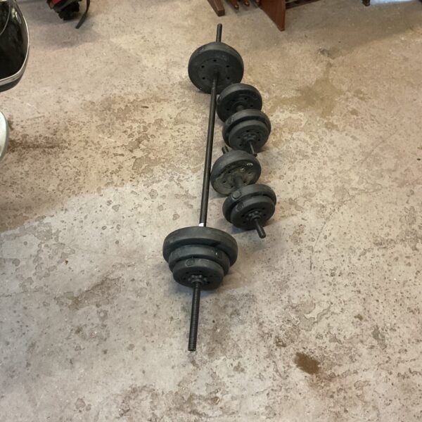 Black barbell and dumbbell set for home fitness and weightlifting.