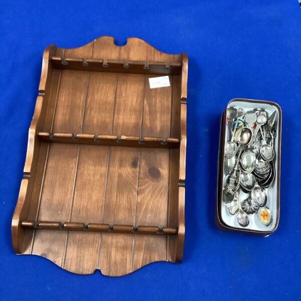 Vintage spoon display shelf with silver spoons on display.