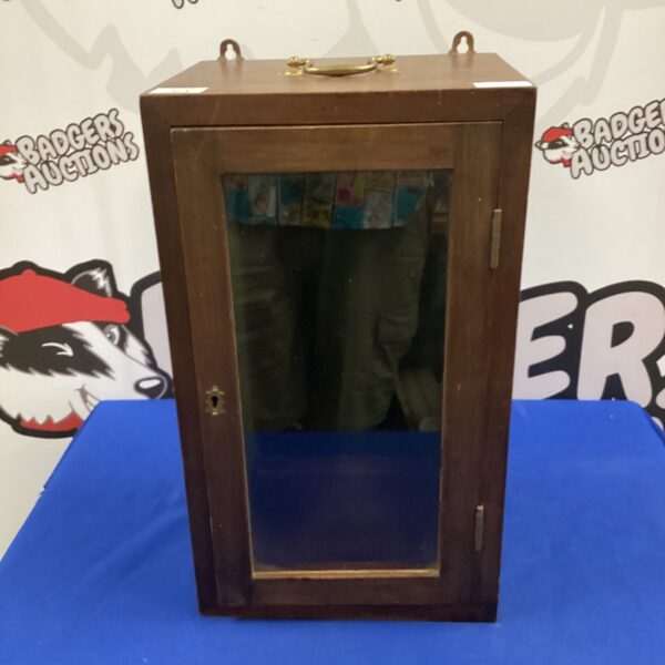 Antique wooden display cabinet with glass door for collectibles.