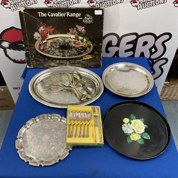 Vintage silverplate trays and cutlery set on a table.