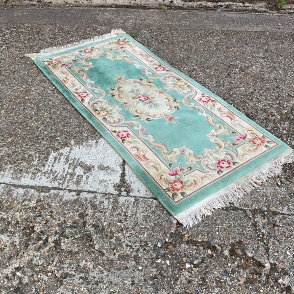 Detailed blue oriental rug with floral patterns and a vintage aesthetic.