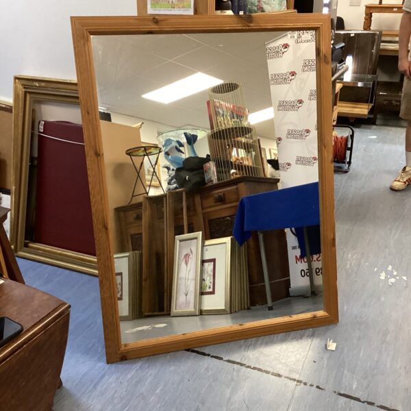 Large pine framed mirror with a rustic aesthetic.