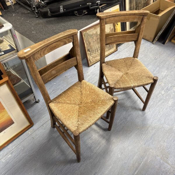 Antique chapel chairs with woven straw seats and backs.