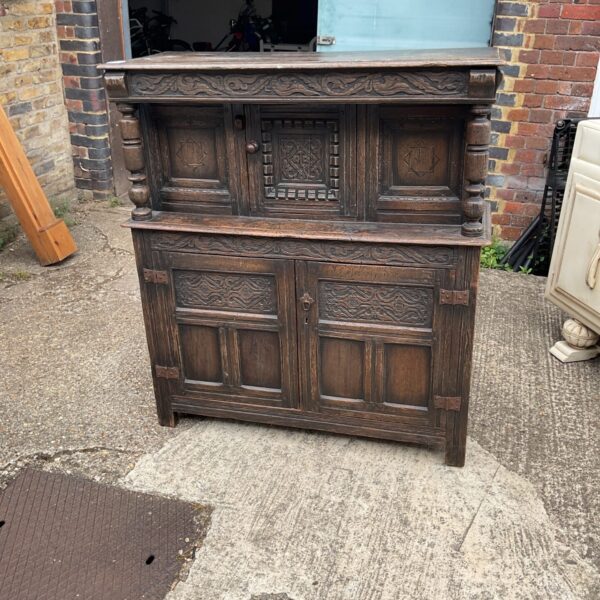 Antique 17th century oak court cupboard with carved details.
