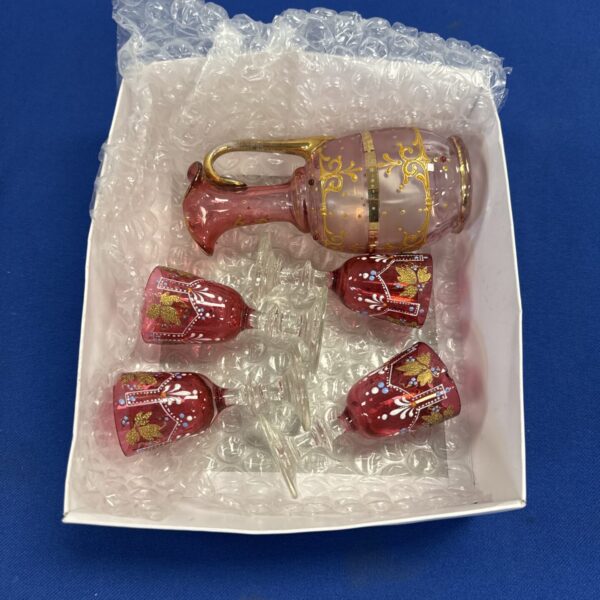 Vintage cranberry glass spirits set with gilded detail.