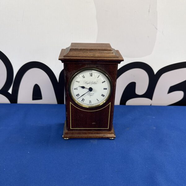 Front view of a vintage Knight & Gibbins mantle clock.