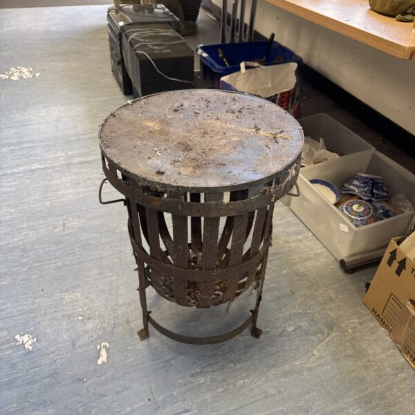 Vintage wrought iron garden fire basket with lid for outdoor use.