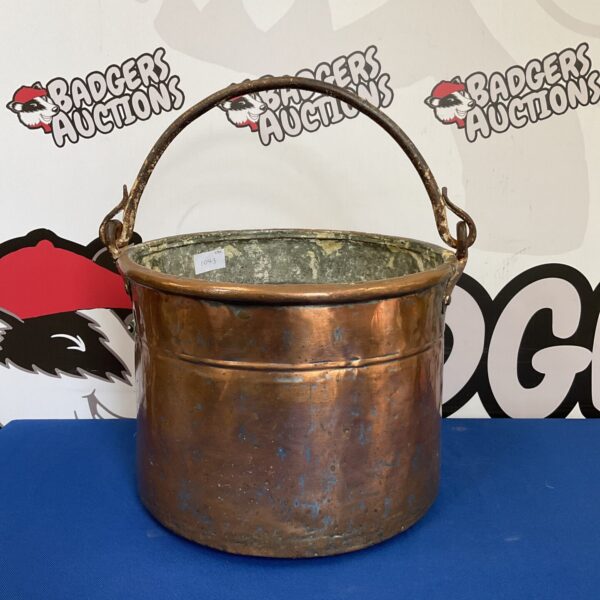 Antique copper bucket with a rustic patina, ideal for farmhouse decor.
