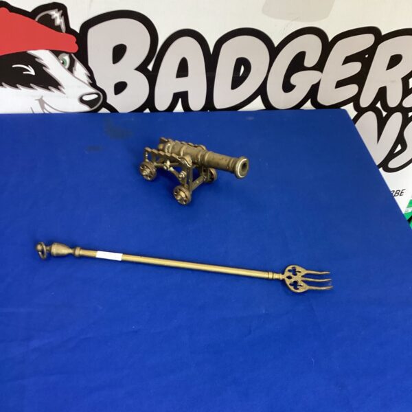 Antique toasting fork and miniature brass cannon collectible.