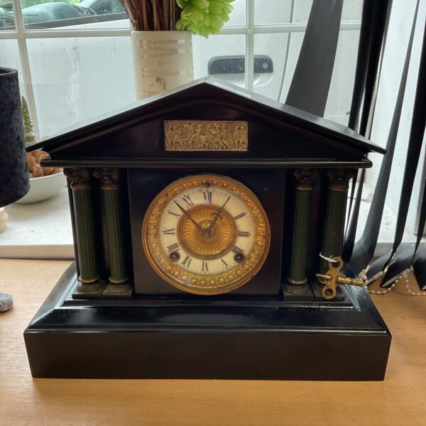 Antique March 1906 metal mantle clock with four pillars.