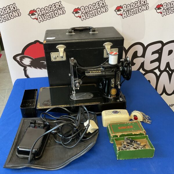 Vintage Singer 221 Featherweight sewing machine with accessories.