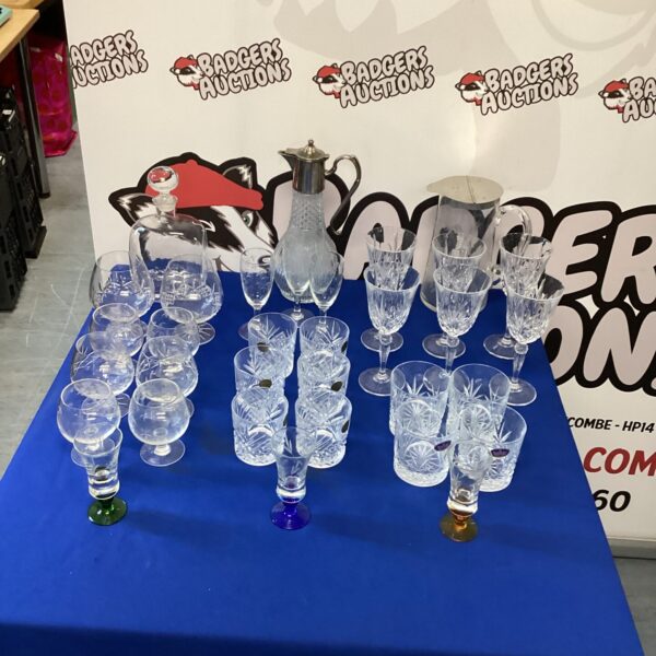 Assorted vintage crystal glasses and decanters on display.