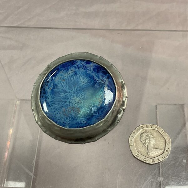 Antique Ruskin roundel brooch with vibrant blue enamel and silver frame.