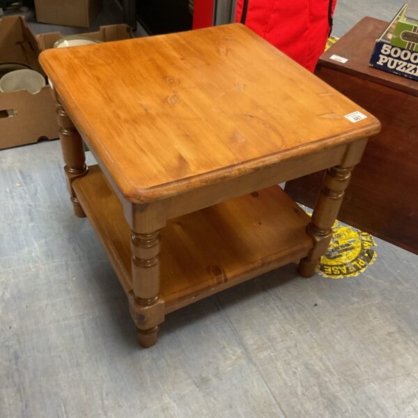 Small pine side table with a single shelf and turned legs.