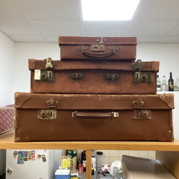 Lot of three vintage brown leather suitcases for collectors.