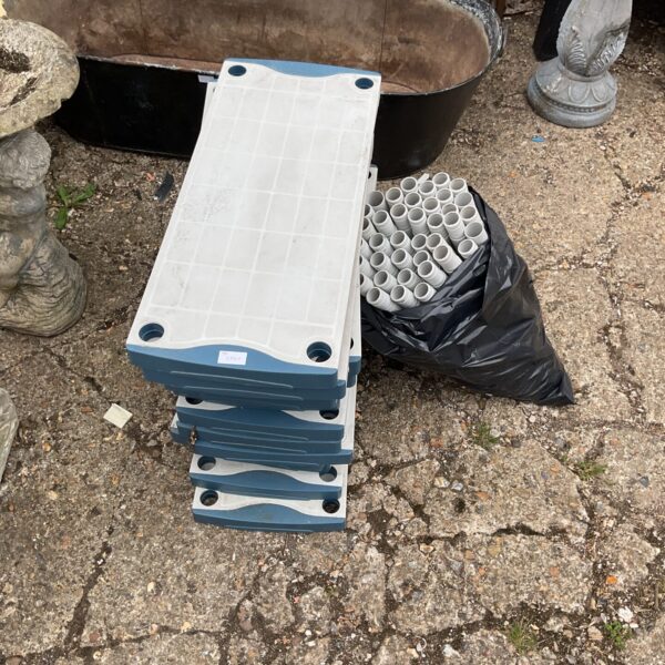 Stacked sections of a durable plastic shelving unit for storage.