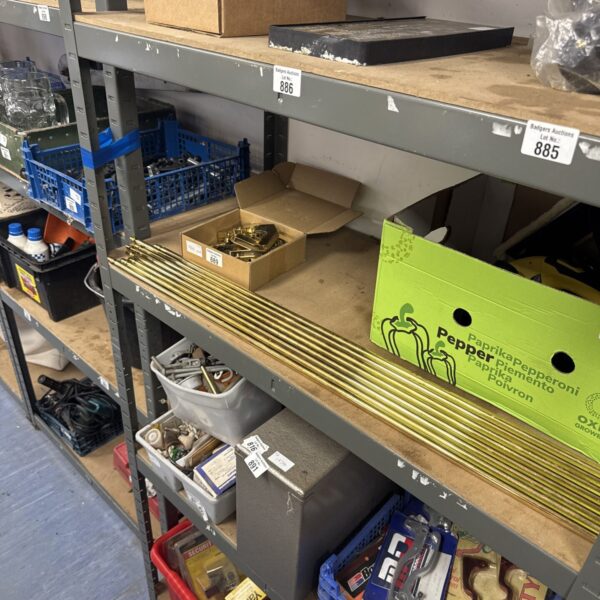 Lot of vintage brass stair rods on shelving.