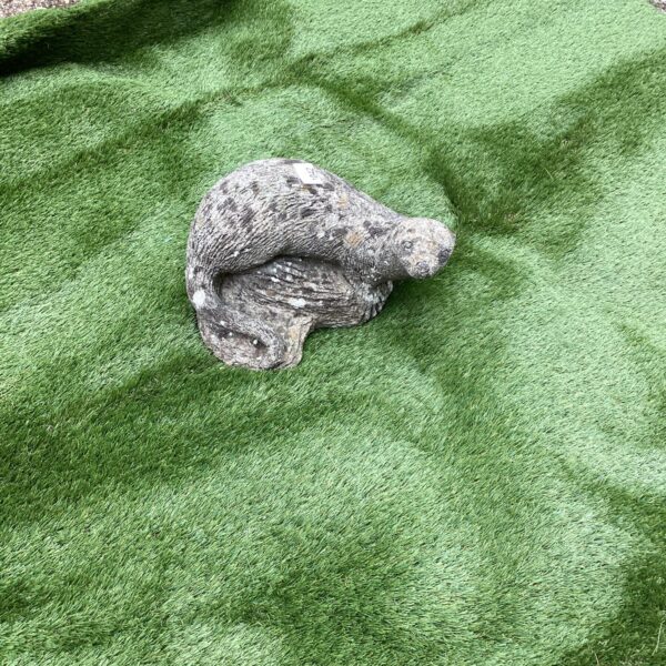 Detailed concrete otter garden ornament for outdoor display.