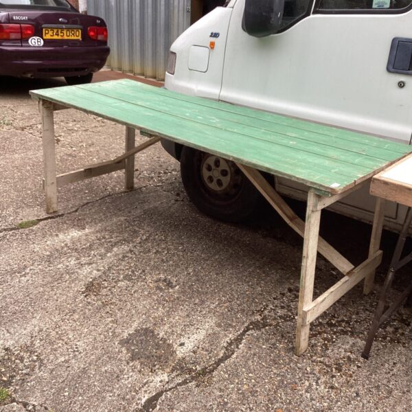 Weathered wooden shed table in a garden setting.
