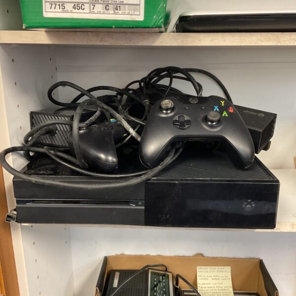 Microsoft Xbox One console with controllers and cables setup.