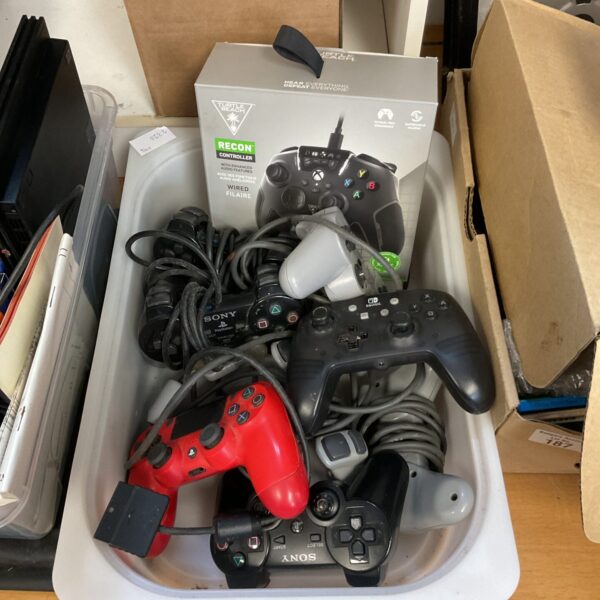 Mixed lot of gaming controllers including PS4 and Nintendo Switch gamepads.