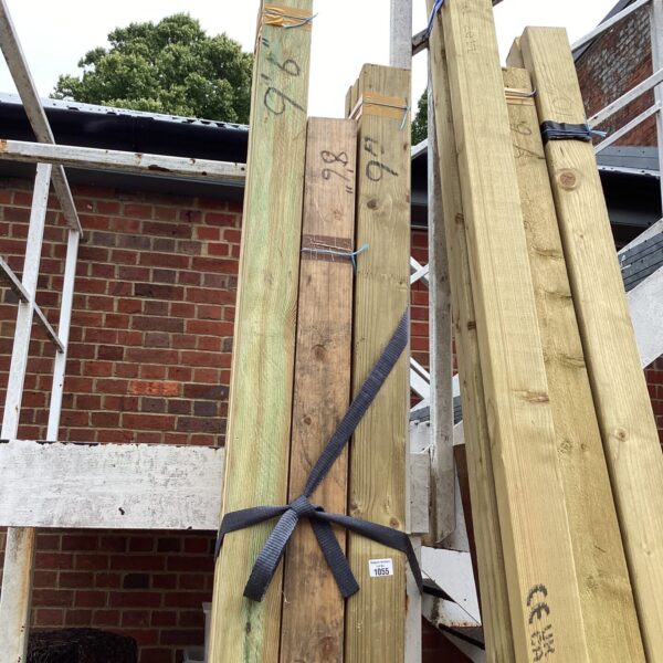 Three bundles of 9’6” timber secured with strapping outdoors.