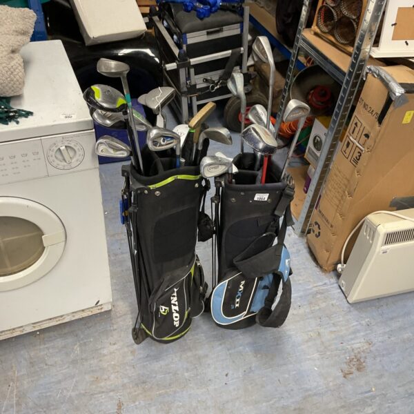 Selection of used golf clubs including junior clubs in bags.