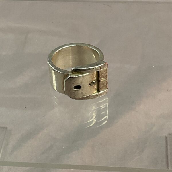 Close-up of vintage silver buckle ring, adjustable and unique.
