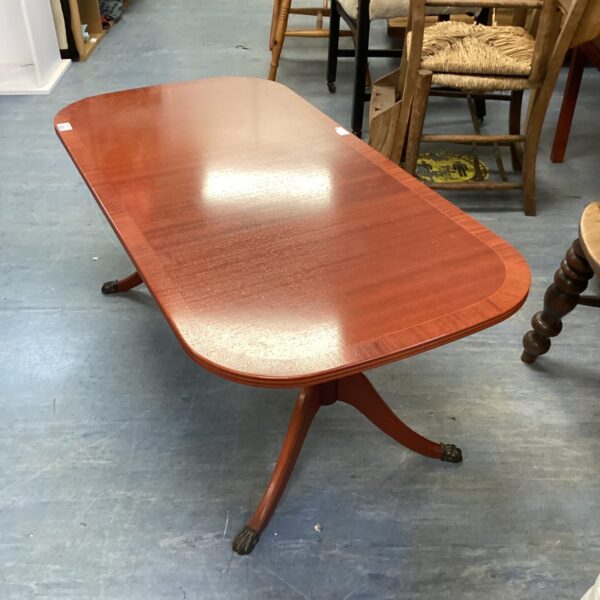 Vintage mahogany claw foot coffee table with oval tabletop.