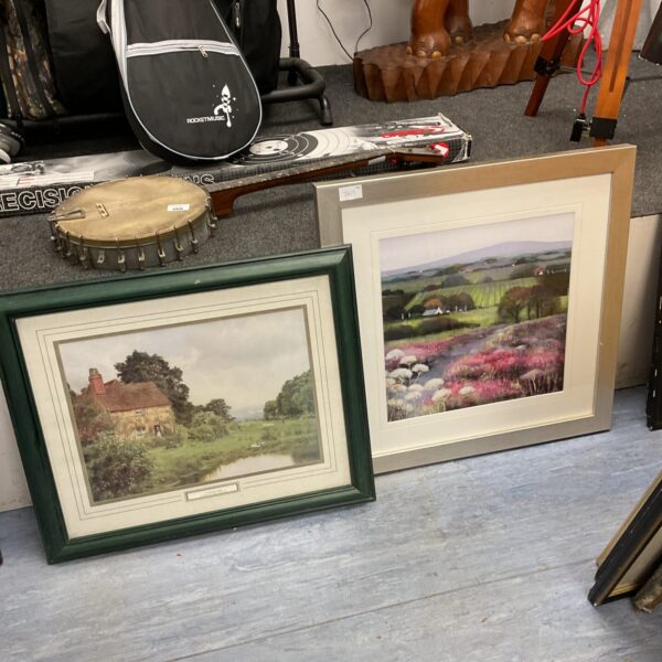 Framed country scene print of a cottage in a landscape.