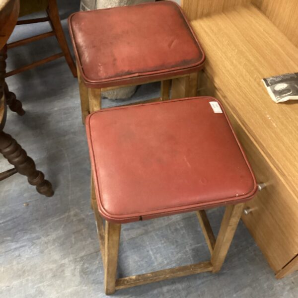 Pair of vintage leather top wooden stools with rustic charm.