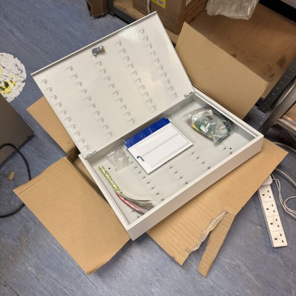 New wall-mounted key box with numbered hooks and labels for key storage.