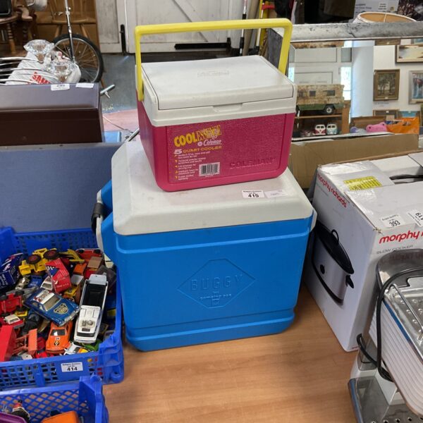 Lot of red, blue, and wheeled cooler boxes for outdoor use.