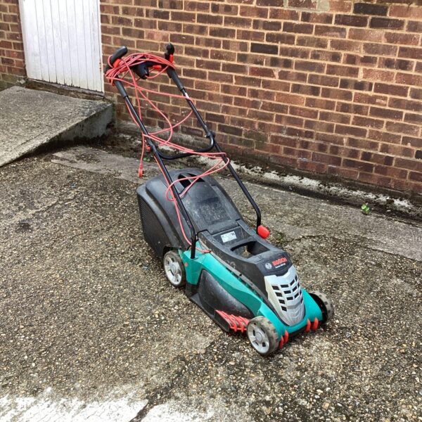 Bosch Rotak electric lawn mower in a garden setting.