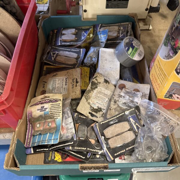 Assorted motorcycle parts in a tray, ideal for repairs and restoration.