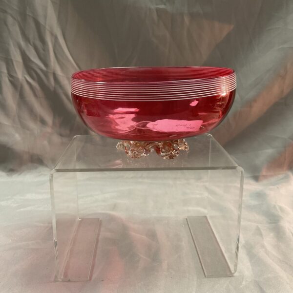 Vibrant antique cranberry glass vase with a footed base.