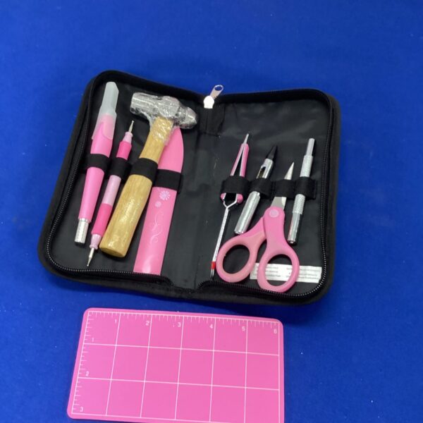 Open model makers tool kit with pink handled tools.