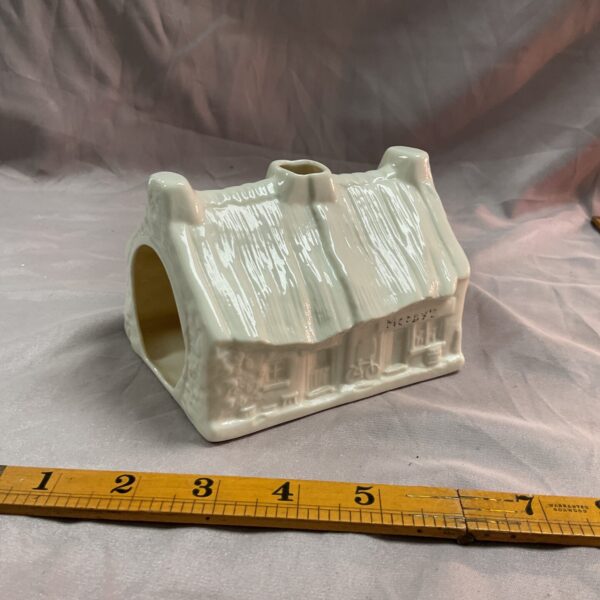 Front view of vintage Belique tea light house with thatched roof.