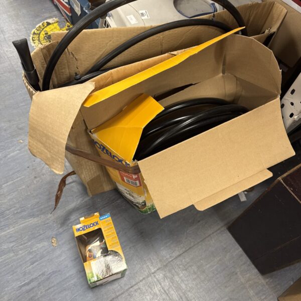 Black Hozelock garden hose inside yellow packaging.