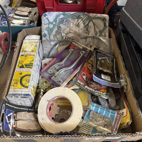 Tray of assorted vintage motorcycle parts and components.