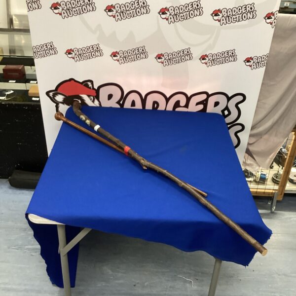 Vintage walking staffs with scout badges, a collectible outdoor item.