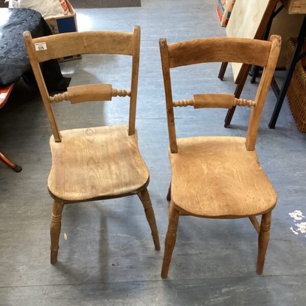 Pair of vintage pine kitchen chairs with rustic charm.