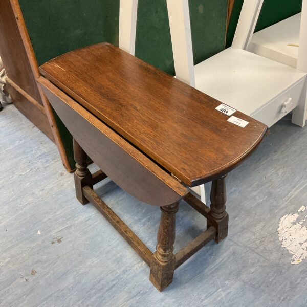 Antique oak drop leaf table with turned legs and a drawer.