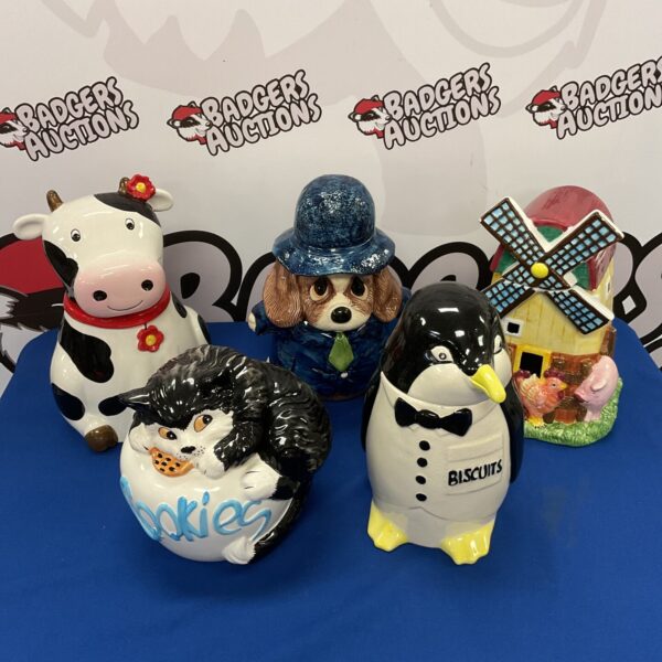 Group of vintage ceramic cookie jars, including penguin and cow.