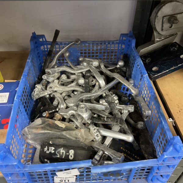 Tray of used motorbike brake levers for restoration or spares.