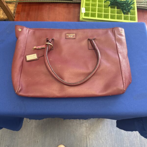 Brown leather Paul Costelloe handbag on a table.