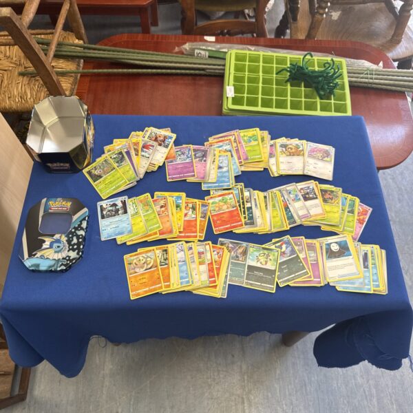 Pokemon card lot with metallic storage tin for collectors.