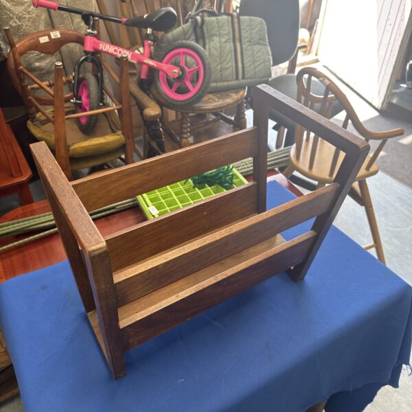 Vintage wooden magazine rack for storing reading materials.