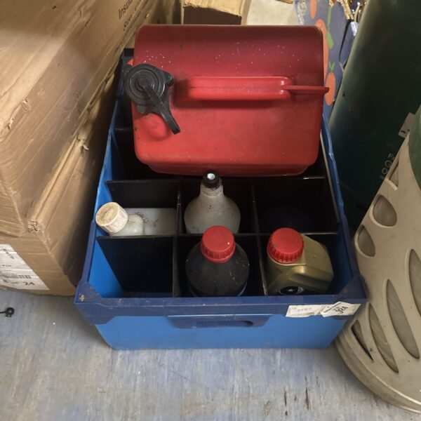 Assorted motoring fluids and a red Jerry can in a lot.